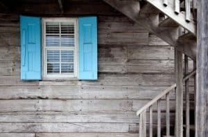 A timber siding showing a blue and white window frame and a series of stairs