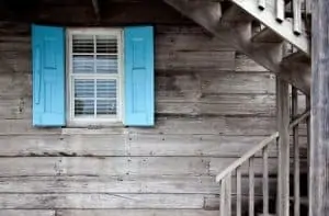 A timber siding showing a blue and white window frame and a series of stairs