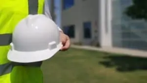 A hardhat and safety vest worn by a person wearing a ring