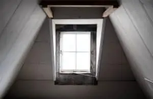 Bright natural light shining through a closed, wooden attic window