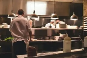 Men in white chef uniforms working in the kitchen