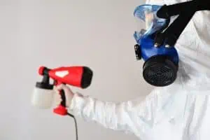A Person Wearing PPE with A Spray Gun