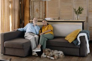 Senior Couple Sitting on The Couch with their Dog